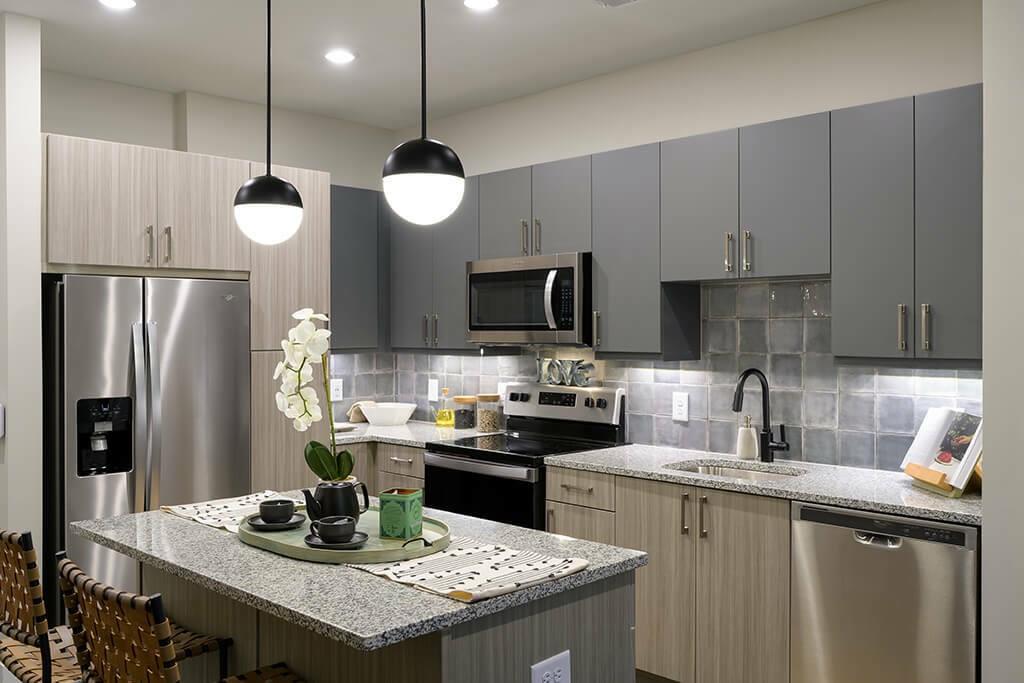 125 Milton Avenue Southeast, Unit S1 Atlanta, GA 30315 - Photo 36 of 41 a kitchen with stainless steel appliances granite countertop a sink a stove a refrigerator a kitchen island with wooden cabinets and floor