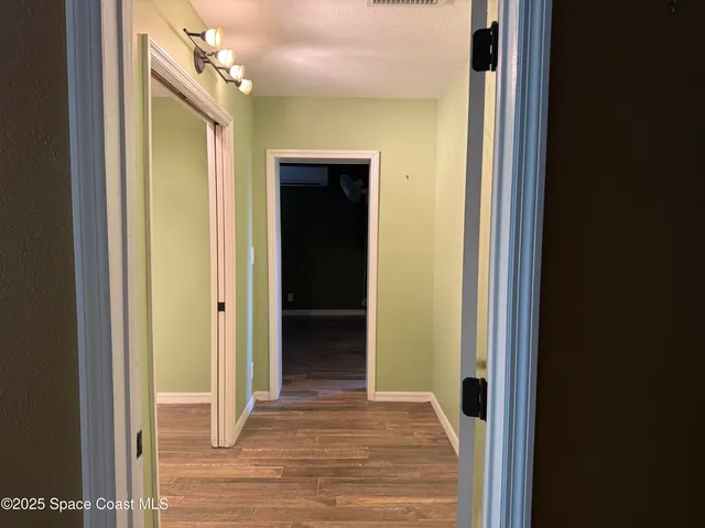a view of a hallway with wooden floor