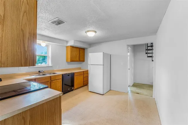 a large kitchen with a refrigerator and a sink