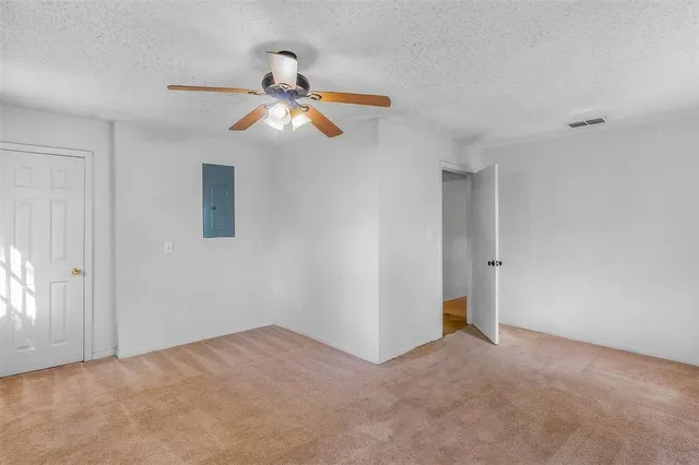a view of a room with a ceiling fan and a window