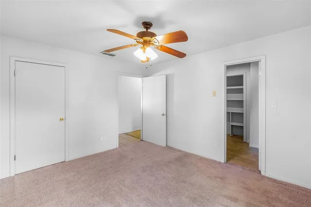 a view of an empty room with a ceiling fan