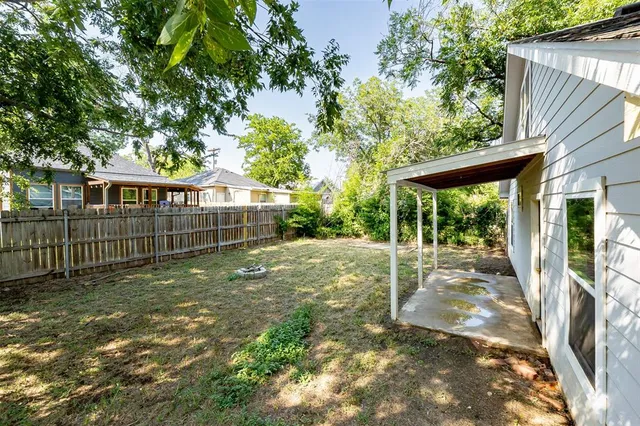 a view of a house with backyard and a tree