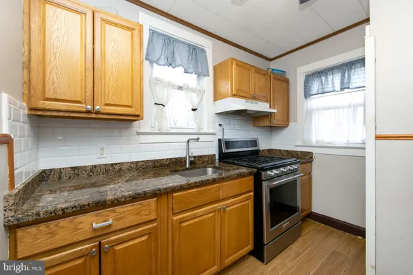 a kitchen with stainless steel appliances granite countertop a sink a stove and a microwave