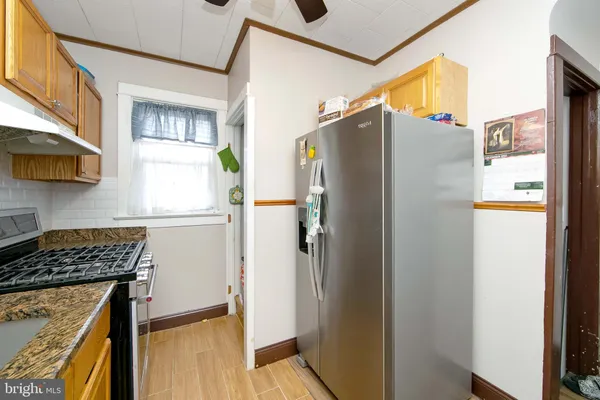 a kitchen with stainless steel appliances granite countertop a refrigerator and a stove