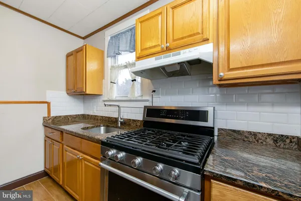 a kitchen with stainless steel appliances granite countertop a stove and a sink