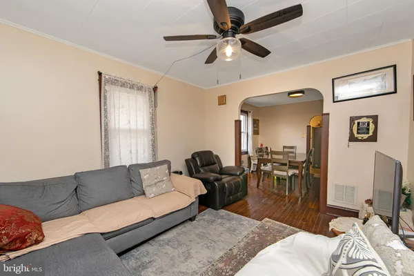 a living room with furniture a flat screen tv and a window
