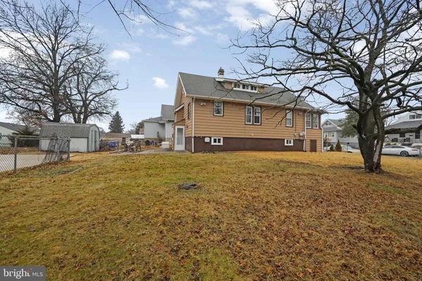 a front view of a house with a yard covered with snow and trees