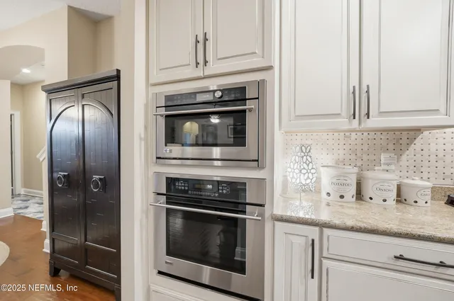 a kitchen with granite countertop white cabinets stainless steel appliances and sink