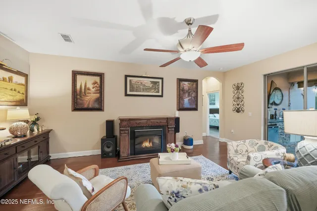 a living room with furniture kitchen view and a flat screen tv