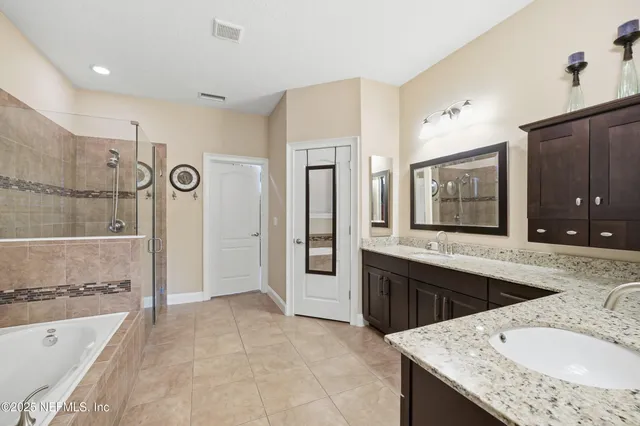 a large bathroom with a granite countertop tub sink shower and mirror