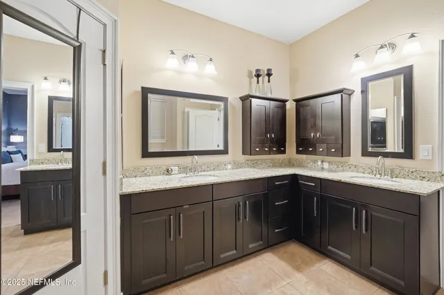 a bathroom with a granite countertop sink double and mirror