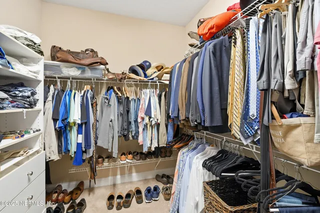 a view of walk in closet with clothes