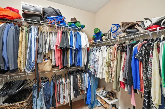a view of walk in closet with clothes