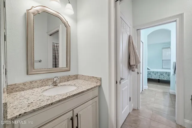 a en suite bathroom with a granite countertop sink and a mirror