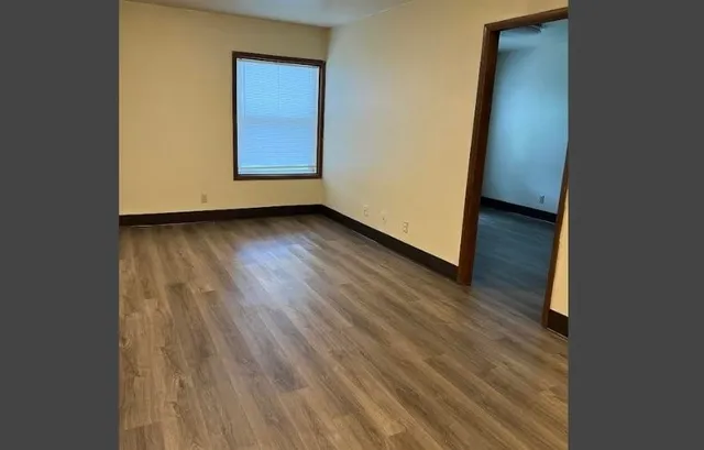 an empty room with wooden floor and closet