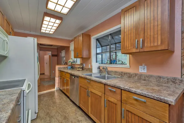 a dining hall with stainless steel appliances granite countertop a stove a sink and a refrigerator
