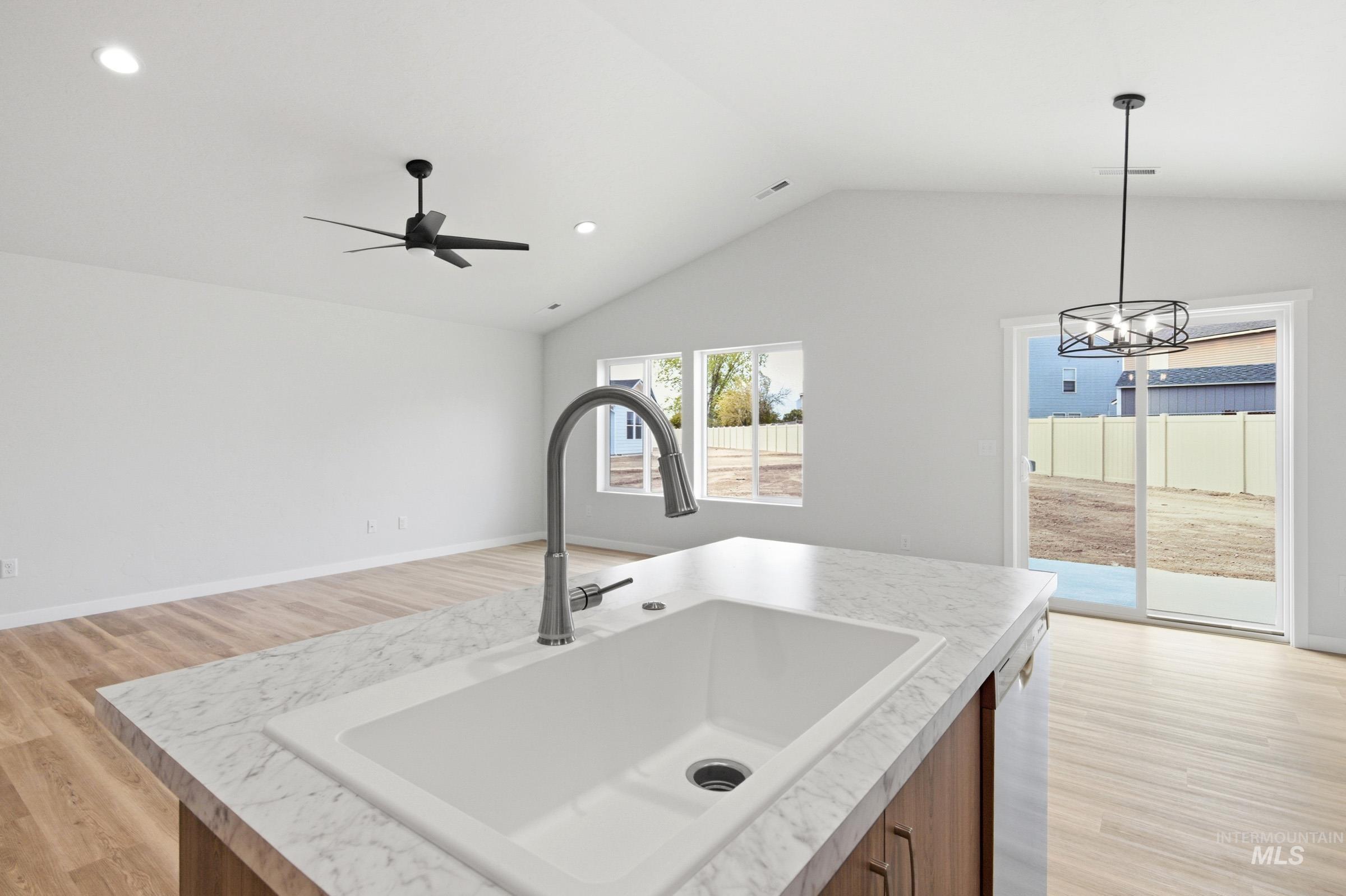 13735 Inman Court Caldwell, ID 83607 - Photo 19 of 20 Kitchen featuring light wood-style floors, wood finish cabinets, light countertops, open floor plan, and vaulted ceiling