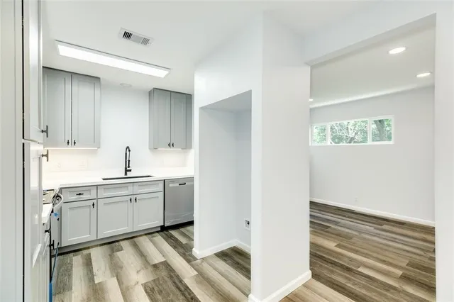 a kitchen with white cabinets and sink