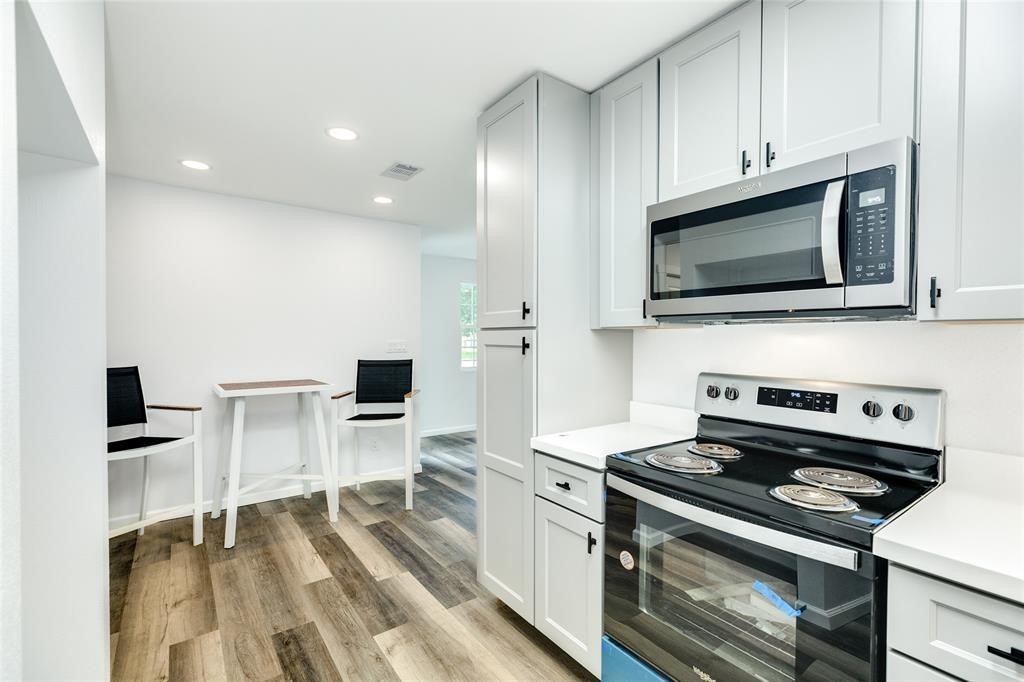 846 South Anderson Street Angleton, TX 77515 - Photo 10 of 29 a kitchen with a stove and a microwave