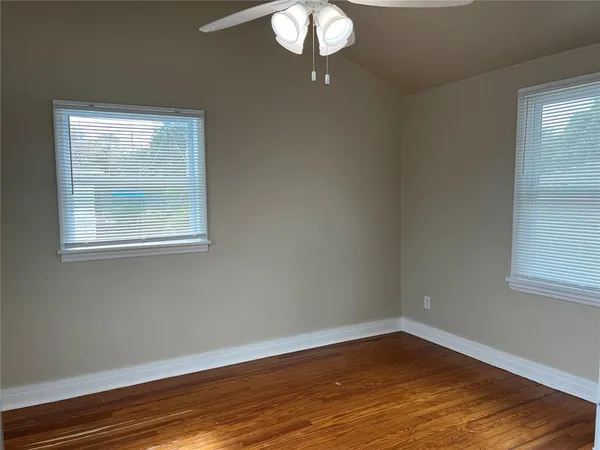 a view of a room with wooden floor and windows