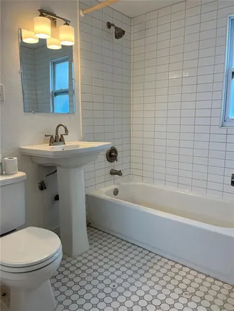 a bathroom with a bathtub a sink a toilet and a mirror