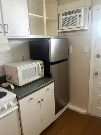 a kitchen with granite countertop white cabinets and white appliances
