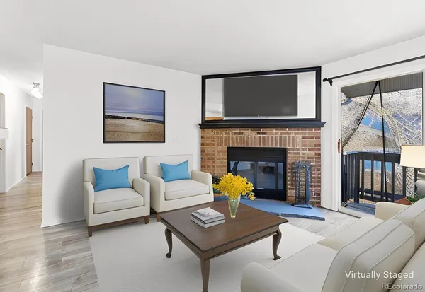 a living room with furniture a flat screen tv and a fireplace