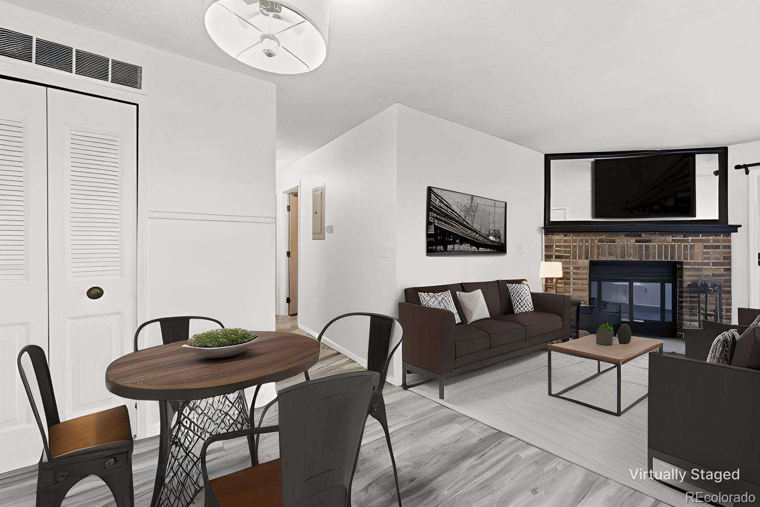 7883 Allison Way, Unit 302 Arvada, CO 80005 - Photo 11 of 29 a living room with furniture a flat screen tv and a fireplace