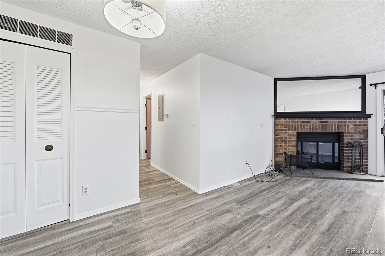 7883 Allison Way, Unit 302 Arvada, CO 80005 - Photo 12 of 29 a view of a livingroom with wooden floor and a fireplace