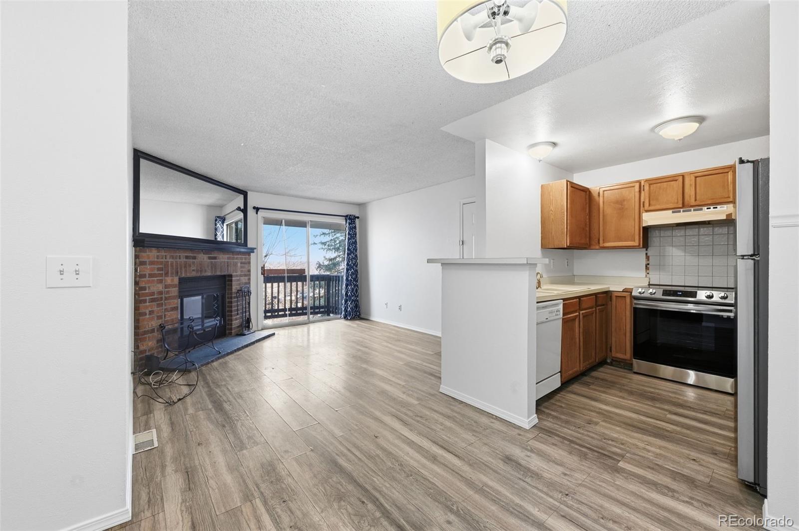 7883 Allison Way, Unit 302 Arvada, CO 80005 - Photo 13 of 29 a kitchen with stainless steel appliances granite countertop a refrigerator a stove and a wooden floors