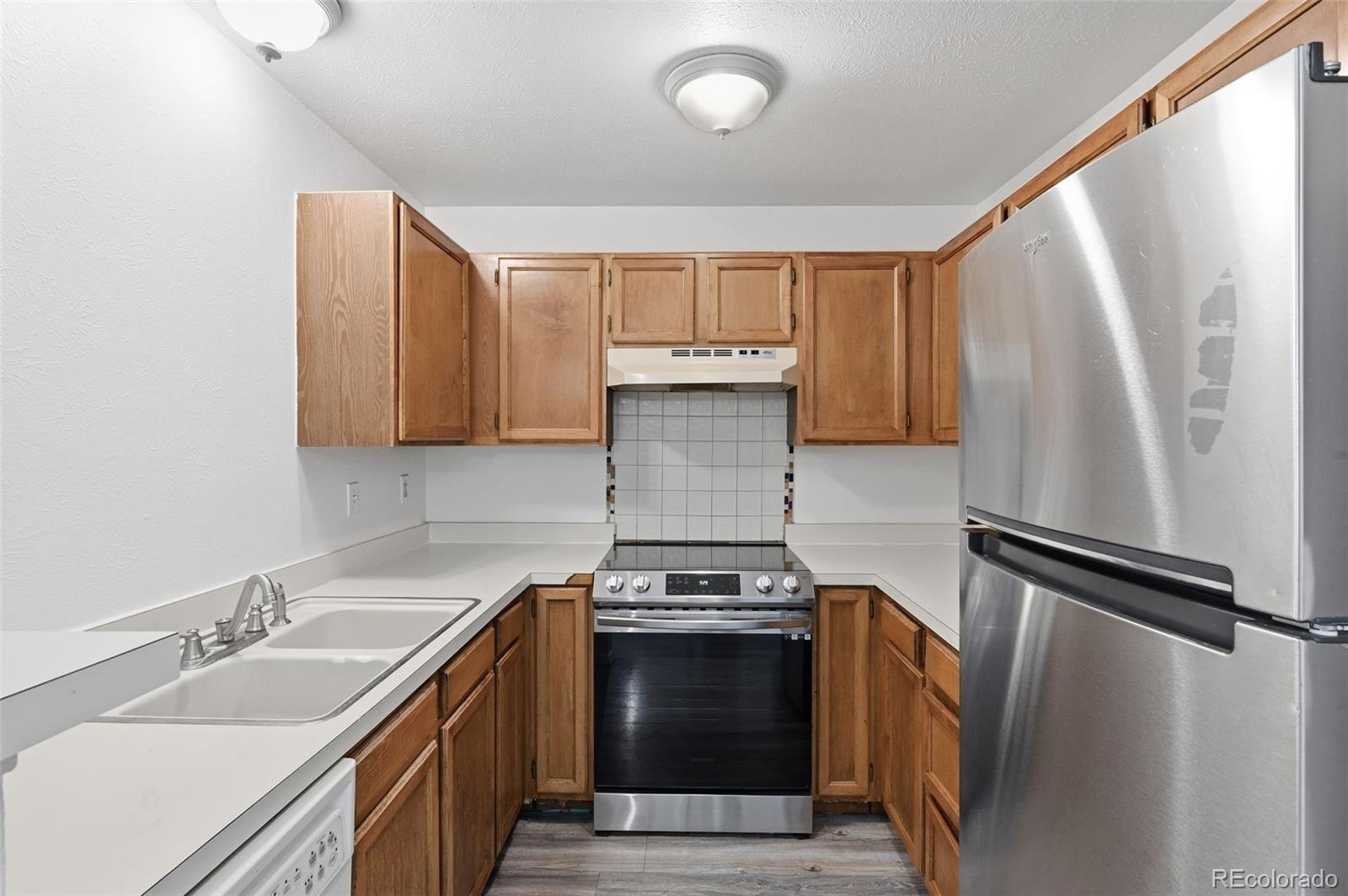 7883 Allison Way, Unit 302 Arvada, CO 80005 - Photo 14 of 29 a kitchen with a refrigerator sink and stove