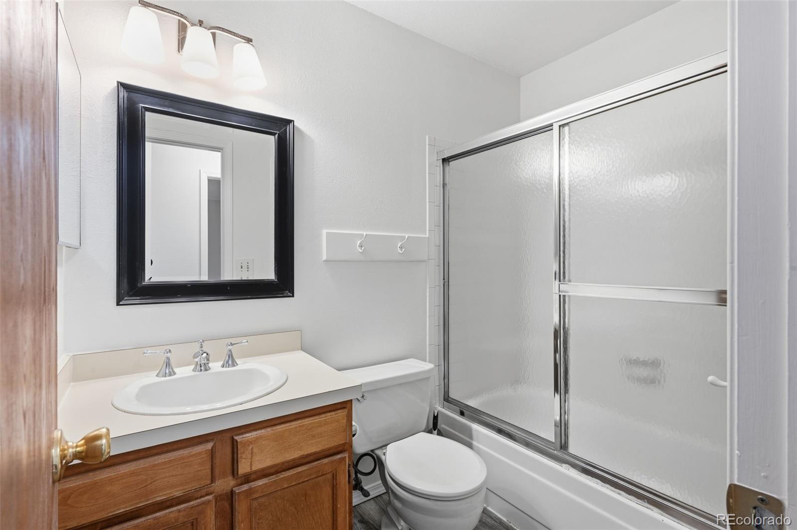 7883 Allison Way, Unit 302 Arvada, CO 80005 - Photo 17 of 29 a bathroom with a toilet a sink and a mirror