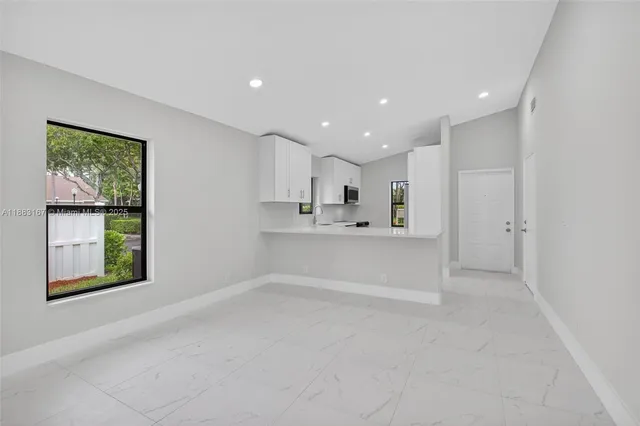 a view of a kitchen with white cabinets