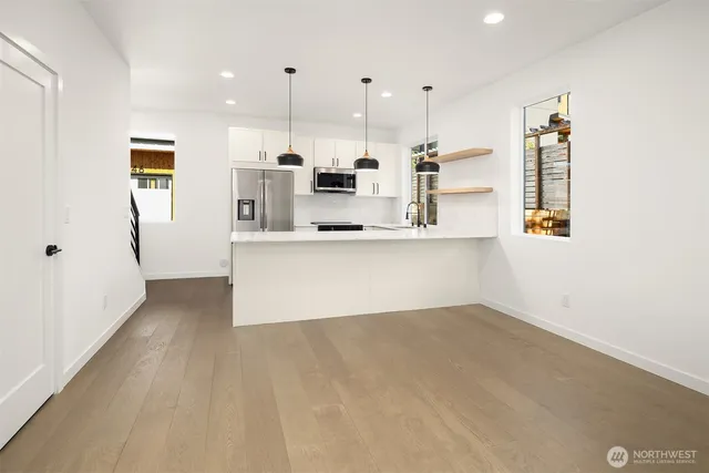a large white kitchen with kitchen island a sink a stove and a refrigerator