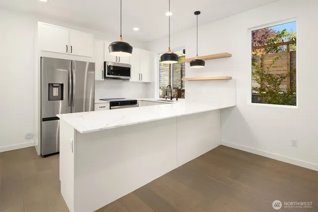 a kitchen with stainless steel appliances granite countertop a sink a refrigerator and a stove