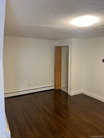 an empty room with wooden floor and closet area