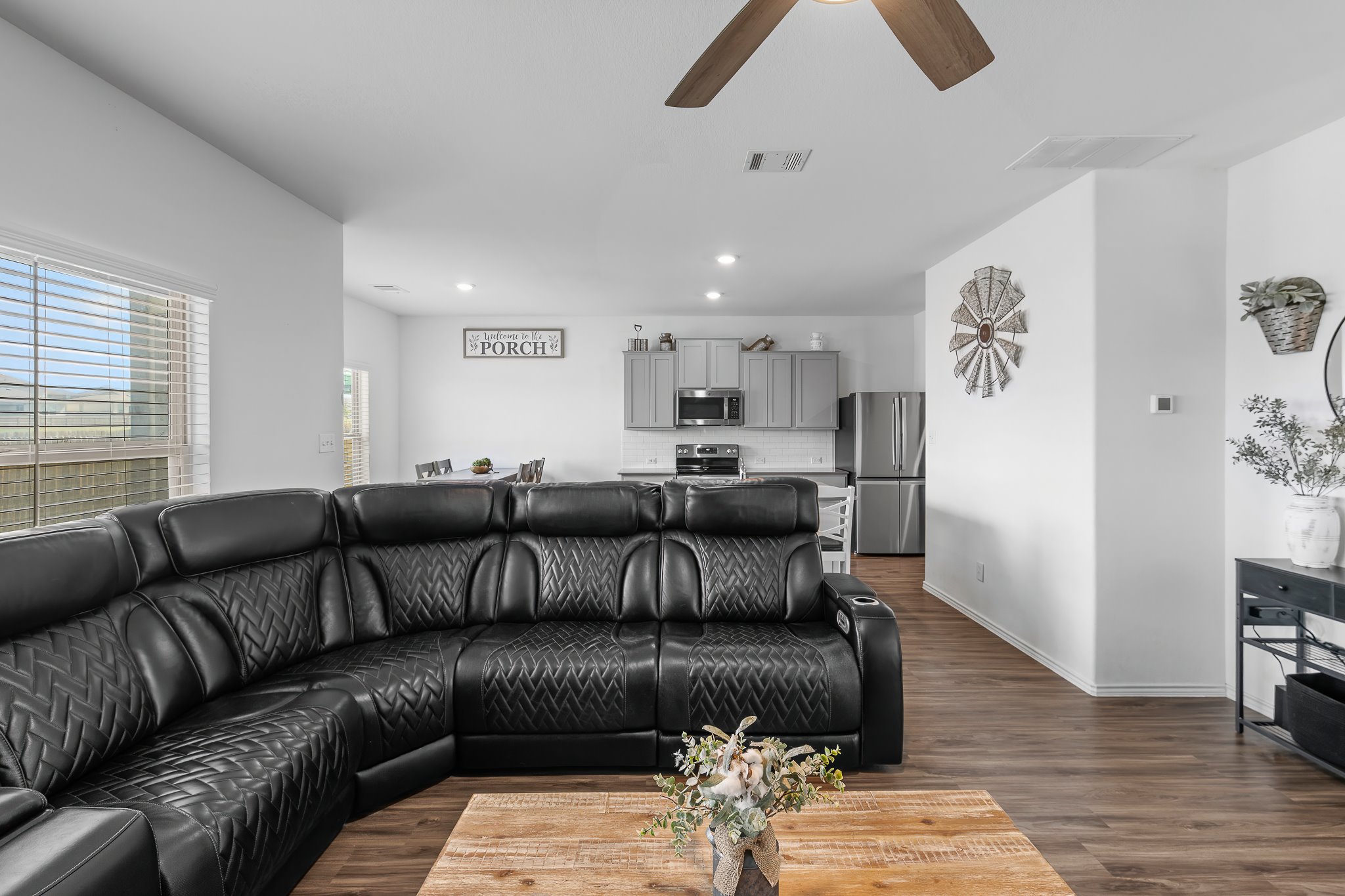 576 Greatest Gift Way Jarrell, TX 76537 - Photo 8 of 37 An open concept living area seamlessly blends into a modern kitchen, creating an inviting space for gatherings.