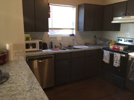 a kitchen with stainless steel appliances a sink stove and cabinets
