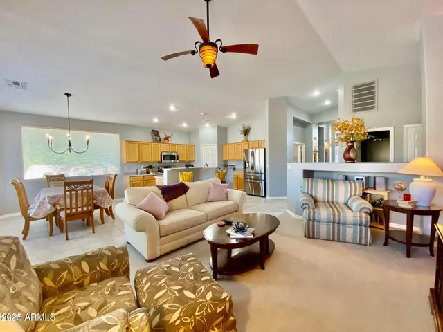 a living room with furniture kitchen view and a chandelier