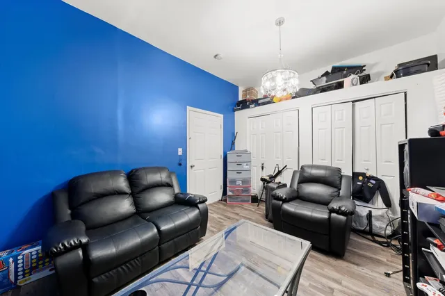 a living room with furniture a chandelier and a flat screen tv