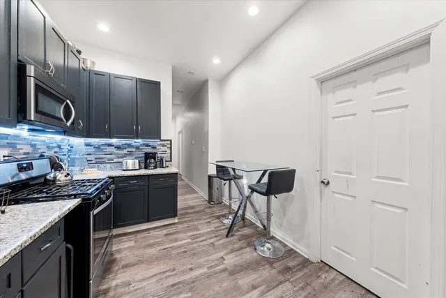 a kitchen with stainless steel appliances granite countertop a stove refrigerator sink and cabinets