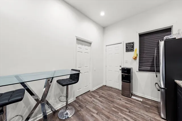 a kitchen with granite countertop a refrigerator and a stove top oven
