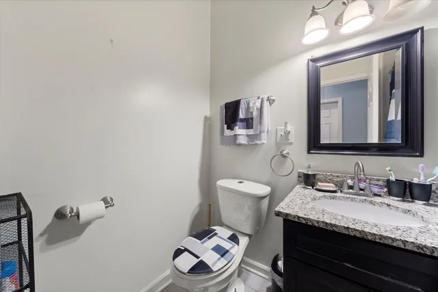 a bathroom with a granite countertop toilet sink and mirror