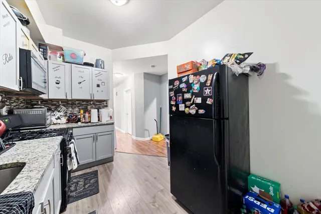 a kitchen with stainless steel appliances granite countertop a refrigerator and a stove
