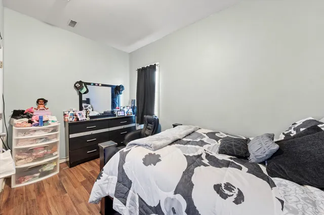a bedroom with a bed and a flat tv screen on dresser