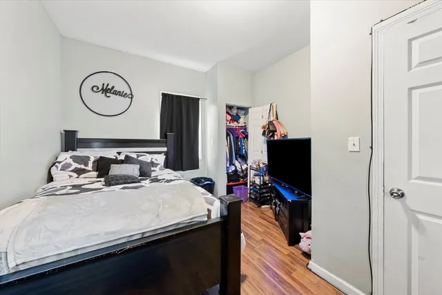 a bedroom with a bed and a flat tv screen on the dresser
