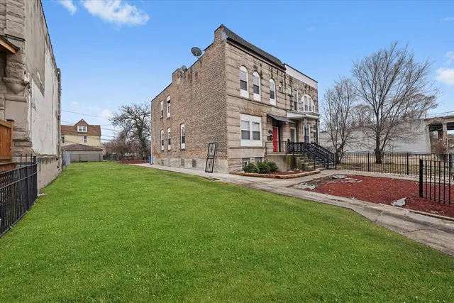 a view of a big building with a big yard and large trees