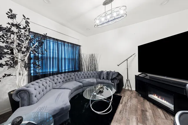 a living room with furniture a flat screen tv and a window