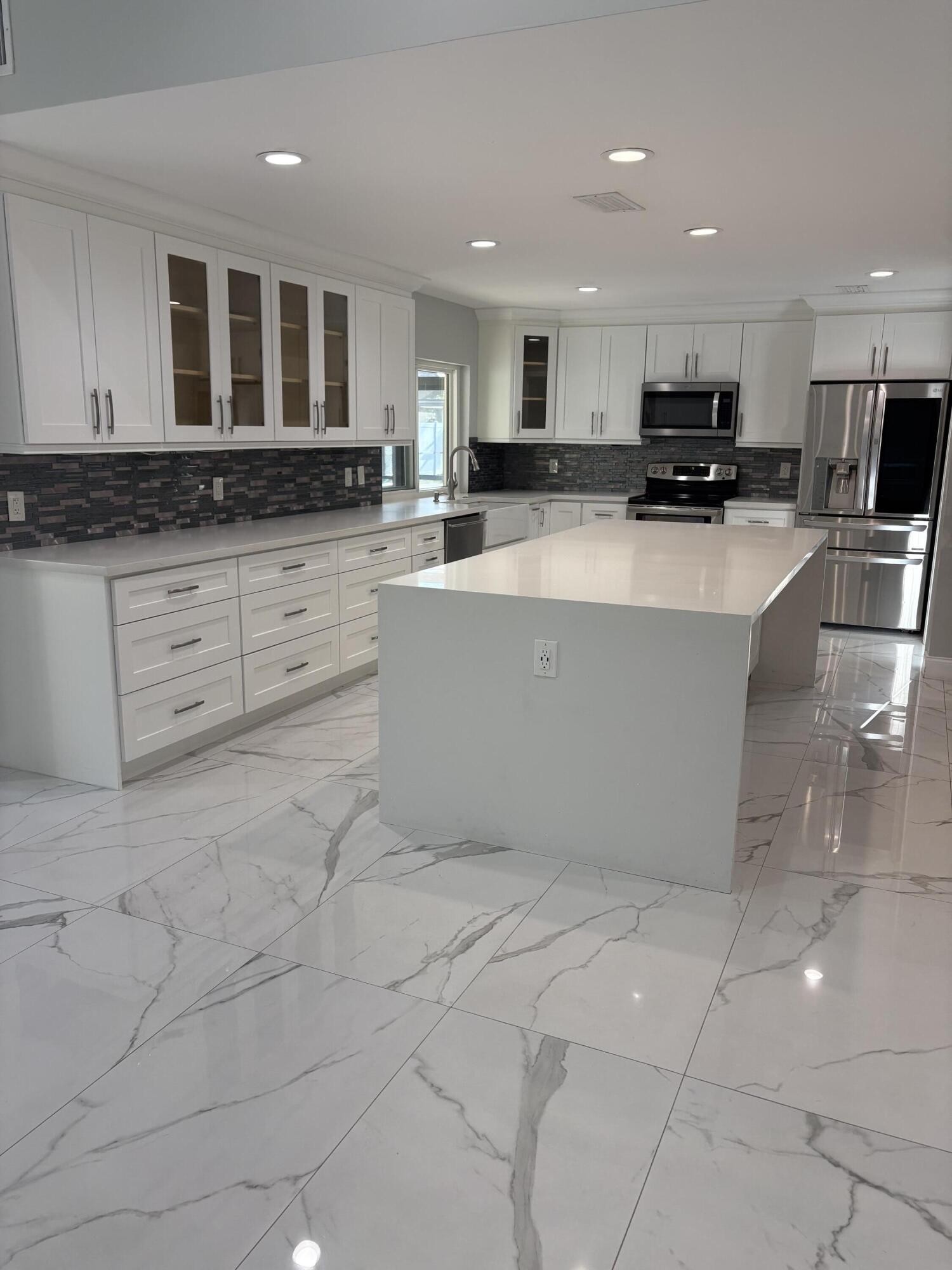 a view of kitchen with stainless steel appliances granite countertop a stove and a sink