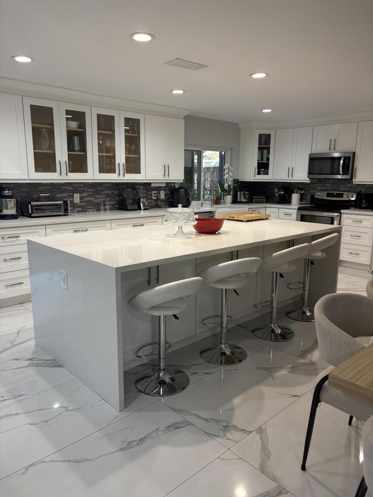 18255 181st Circle South Boca Raton, FL 33498 - Photo 5 of 15 a kitchen with stainless steel appliances granite countertop a sink and a refrigerator